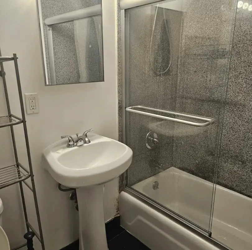 Baño con lavabo y bañera con mampara